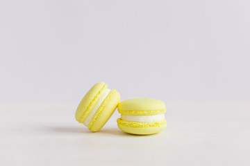 Yellow franch macarons on a white wooden background. Lemon macarons.