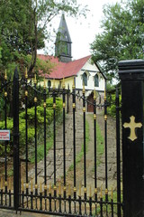 View of a church from out side the gate near the forest