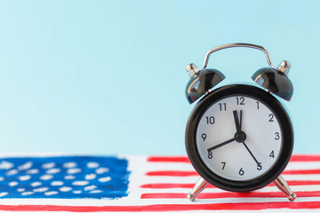 Alarm clock on abstract hand drawn American flag on background. President elections, Memorial Day, 4th of July or Labour Day concept. Learning English grammar tenses. Patriotism and independence.