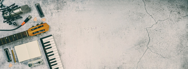 Singer and songwriter flat top board with copy space. Horizontal musician stuf over a concrete flat lay. Suitable for banner - advertising - splash page 