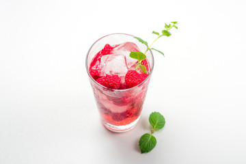 Raspberry alcoholic cocktail with liqueur, vodka, ice and mint on a white background. Raspberry Mojito. Refreshing cool drink, lemonade or ice tea in a glass. Close up, copy space for text