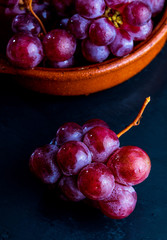 Beautiful close-up of cluster of red grapes (inks) on table. Fresh, raw and water drops.