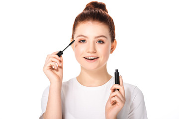 Obraz premium excited female teenager applying mascara, isolated on white