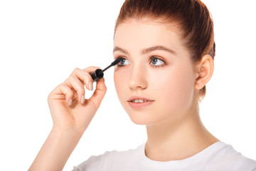 beautiful female teenager applying mascara, isolated on white