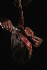 Dry Spanish ham, Jamon Serrano, Bellota, Italian Prosciutto Crudo or Parma ham, whole leg isolated on black background - obrazy, fototapety, plakaty