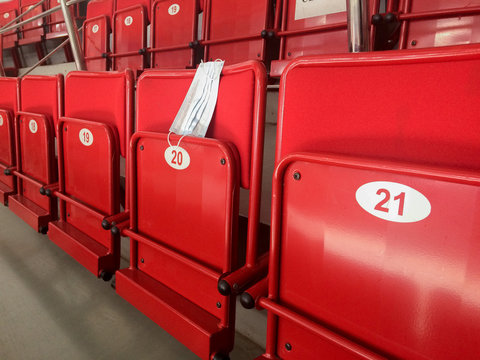Suspension of sports and entertainment events due to the virus. A medical mask lies on an empty stadium seat.