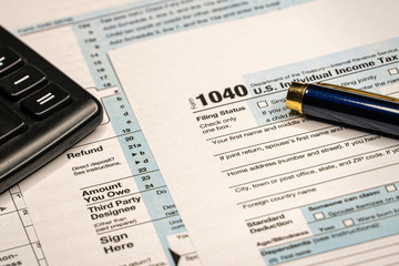 Pen on US TAX form Background. Tax Day concept.