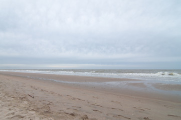 Strand im Regen mit grauen Wolken