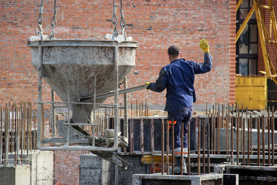 Workers At Construction Site Casting A Concrete Mixture Into The Form, Creating Demountable And Permanent Formwork