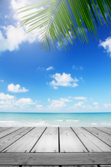 Blurred summer tropical beach background with palm leaves and table wooden. 