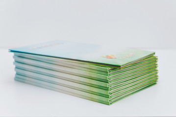a large stack of blue-green books lies on a white surface. finished products of printed photobooks...