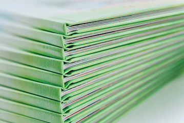 a large stack of blue-green books lies on a white surface. finished products of printed photobooks...