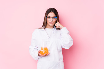 Young chemical woman isolated pointing temple with finger, thinking, focused on a task.