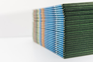 a lot of albums printed in color on a light background. a stack of green books, side view.