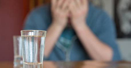 drunk man in depression covers face with hands