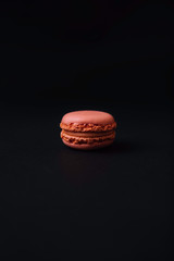 Obraz na płótnie Canvas Stock photo of pink and strawberry flavor macaron on black background.