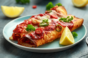 Baked Chicken fillets enchiladas with courgette, salsa sauce and cheese served with lemon wedges...