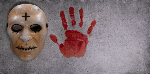 scary mask of a nurse and imprint of a bloody palm on cement © serikbaib