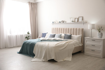 Fototapeta na wymiar Comfortable bed with pillows in room. Stylish interior design