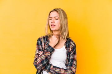 Fototapeta premium Young blonde caucasian woman isolated suffers pain in throat due a virus or infection.