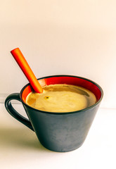 White coffee served in a cup surrounded by white background