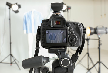Taking pictures of ghost mannequin with modern clothes in professional photo studio, focus on camera
