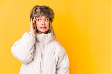 Young caucasian woman wearing a winter clothes isolated shouts loud, keeps eyes opened and hands tense.