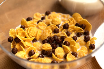 Tasty Bowl Of Crispy Corn Flakes With Chocolate Cereal And Milk On Wooden Table
