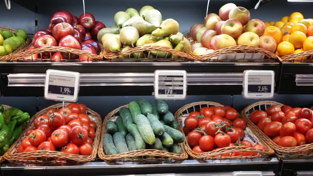 Colorful market counter with large assortment of fresh fruits and vegetables for sale
