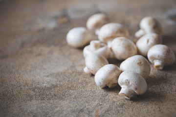 Many champignons lies on an old wooden table. Freshly cut organic champignons. Healthy eating concept. Toning