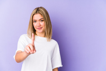 Young blonde caucasian woman isolated showing number one with finger.