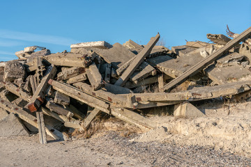 Construction debris - concrete blocks and stones dumped on seashore. Shore strengthening
