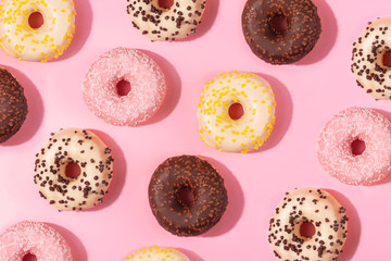 Tasty donuts pattern on pink background. Sweets and desert concept. Flat lay, top view. 