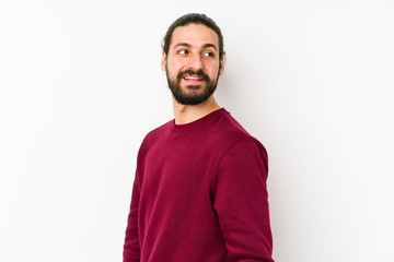 Fototapeta premium Young long hair man isolated on a white background looks aside smiling, cheerful and pleasant.