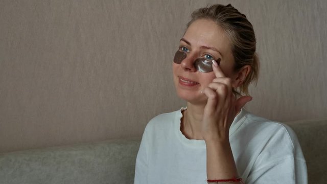 a young beautiful girl with black eye patches. morning facial treatments.