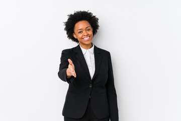 Middle aged african american business  woman against a white background isolated stretching hand at camera in greeting gesture.