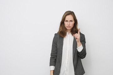Businesswoman is pointing up while looking upset