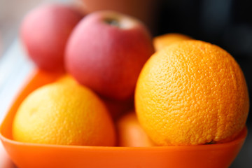 Fresh fruit is in a plate on the windowsill. Apples bananas and oranges.Soft focus. Backgrounds and textures