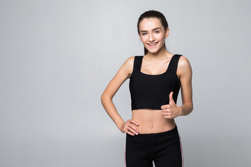 Happy fitness woman showing thumb up isolated on a white background