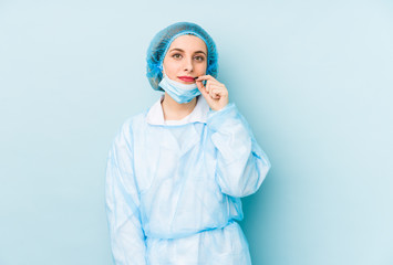 Young surgeon woman isolated with fingers on lips keeping a secret.