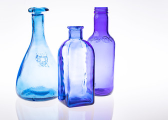 Blue and purple clear bottles translucent on a studio light table with negative space and room for text