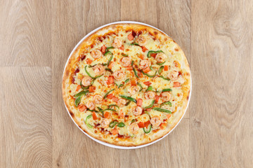 shrimp pizza with vegetables on a wooden background