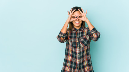 Young woman isolated on blue background excited keeping ok gesture on eye.