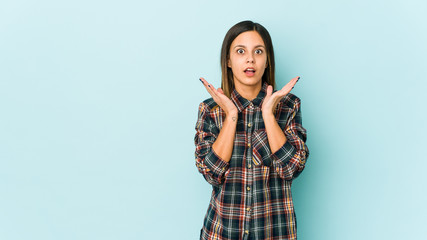 Young woman isolated on blue background surprised and shocked.