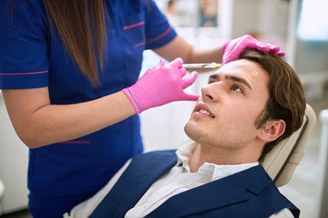 Aestethic intervention on man in beauty clinic