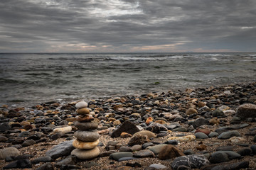 Rocky beach Boulder at the edge of the sea. Tower of stones on the beach.