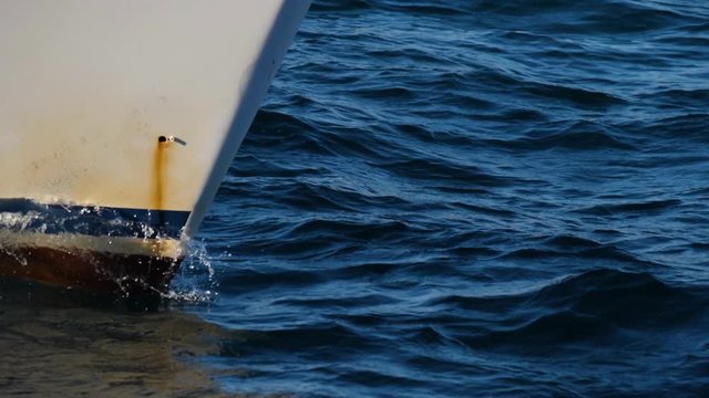 White bow of a ship floating in a blue sea. Water craft cuts waves