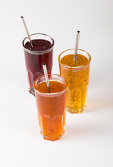 Herbal fruit berry cocktail in a glass, pineapple with Basil, pomegranate with mint, sea buckthorn with oregano on a light background