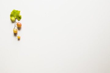 Ripe red grape with leaves isolated on white