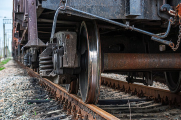 A large image of the wheel of a railway car to carry cargo standing on the tracks